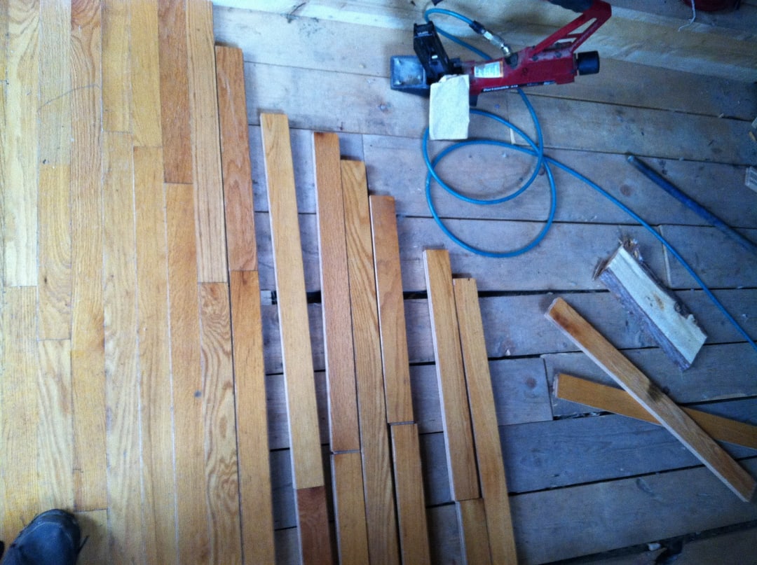 Flooring nailer and new boards mid-install over the subfloor
